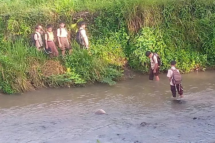 Sejumlah siswa SDN Petir 04 berangkat sekolah dengan menyeberangi Sungai Cihideung. (ISTIMEWA)