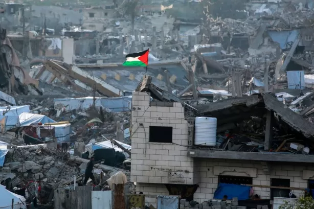 Bendera Palestina berkibar ditengah bangunan yang runtuh  (Gemalantang.com/AFP)