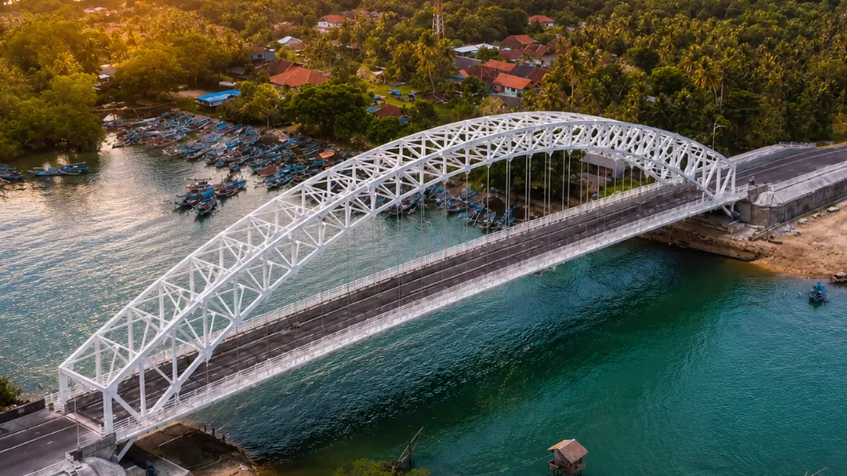 Kemegahan struktur pelengkung baja Jembatan Sodongkopo Pangandaran yang kini jadi spot favorit baru wisatawan untuk berburu senja. (BeritaWisata.Com/RaufNuryama)