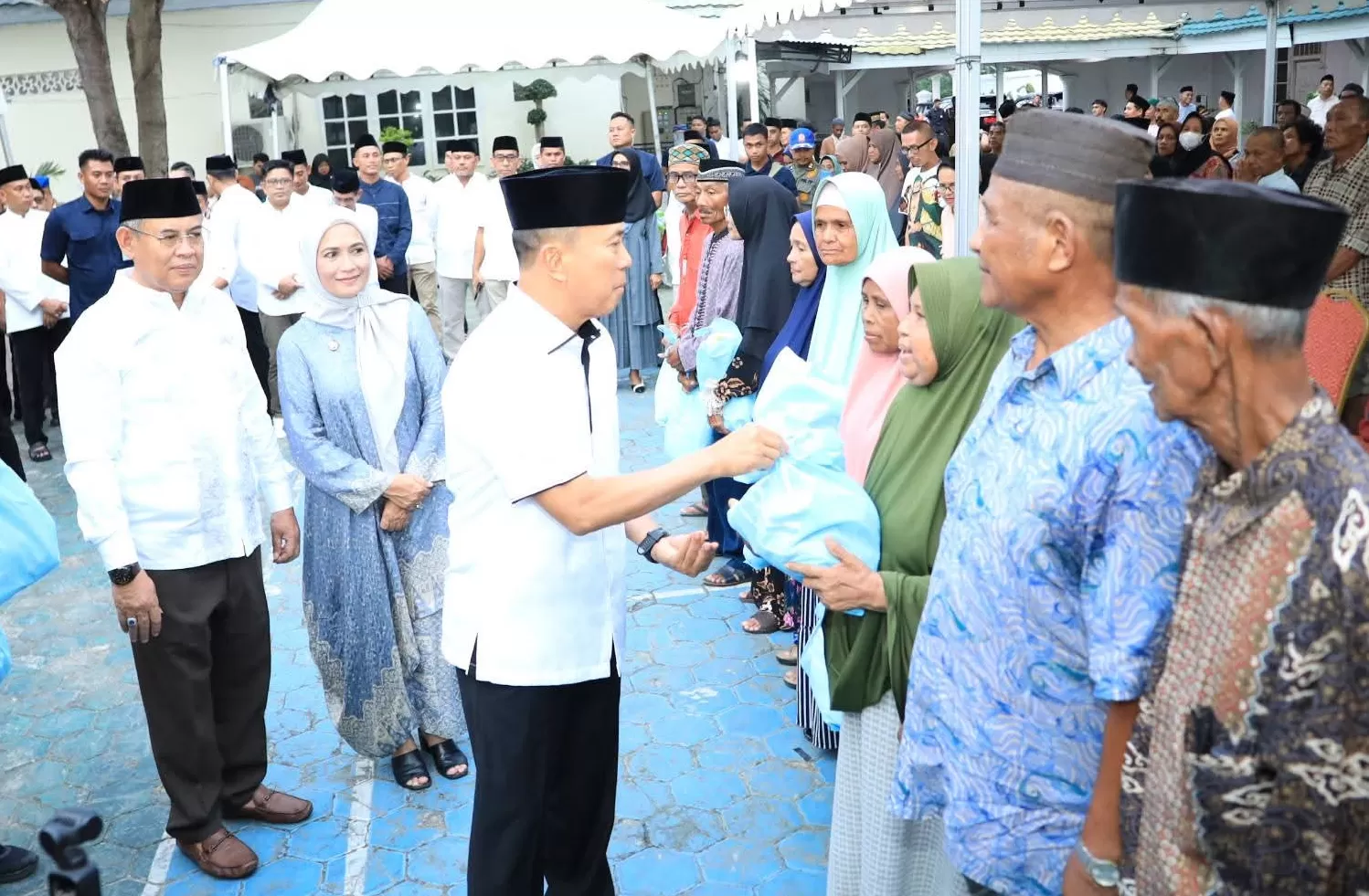 Gubernur Sultra saat menyerahkan paket sembako lansia dalam agenda safari Ramadan di Baubau. 