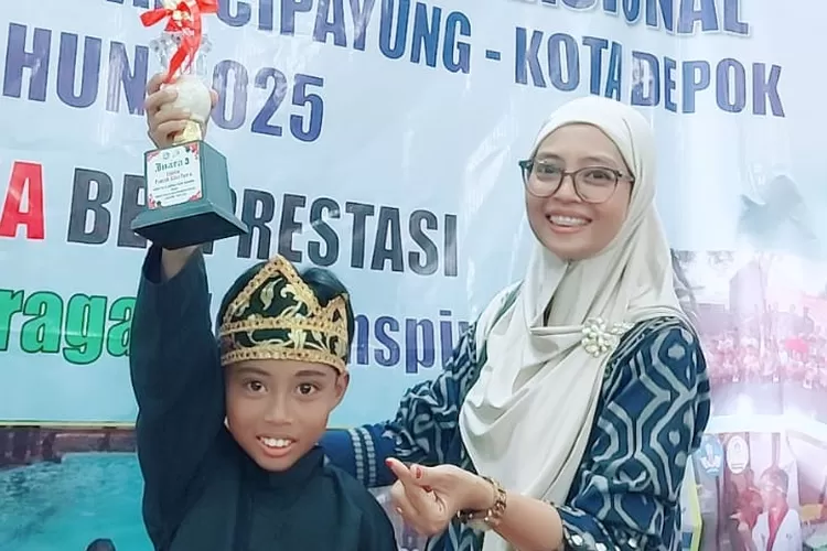Alkhalifi Zikri Akbar (kiri) didampingi dan sang Ibu, Atik Ainul Mufarikah saat mengangkat piala kemenangan dalam ajang O2SN 2025  Tingkat Kecamatan Cipayung.  (DOKUMEN NARASUMBER)