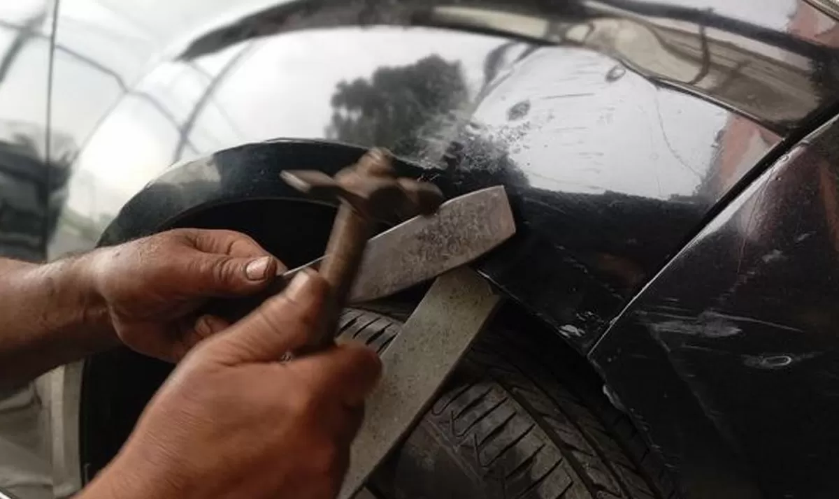 Ilustrasi. Montir bengkel sedang melakukan ketok magic pada mobil penyok./net