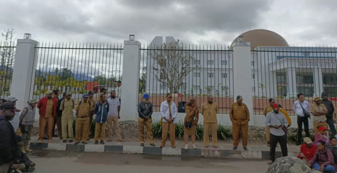 ASN Pemkab Jayawijaya terlihat berdiri di depan kantor bupati. Mereka tidak diperbolehkan masuk menyusul aksi demo para honorer, Senin (28/10/2024). (Cenderawasih Pos/DENI TONJAU)