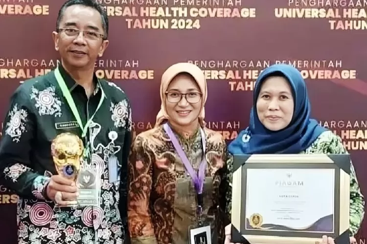 Aspemkesra Setda Kota Depok Gandara Budiana (kiri) bersama Kepala BPJS Kesehatan Kota Depok Elshe Theresia (tengah) dan Ketua Tim Kerja Pelayanan Kesehatan Rujukan dan Pembiayaan Kesehatan Dinkes Kota Depok Fikrotul Ulya usai menerima Penghargaan UHC Award Tahun 2024, Kamis (8/8). (Dokumentasi Dinkes)