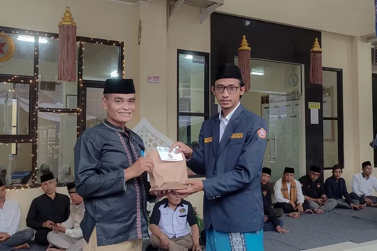 Ketua Panitia Santunan Pangkalanjati, Fuad Nuary (Kanan) menyerahkan secara simbolis dana santunan kepada Lurah Pangkalanjati, Tarmuji (Kiri) untuk diserahkan ke 105 yatim piatu. (KATAR PANGKALANJATI)