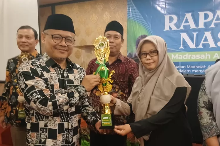 Fitriyani, selaku perwakilan guru dari MAN 1 Bogor, menerima penghargaan secara simbolis dan turut melakukan foto bersama dengan Anis Masykur, Kasubdit Pendidikan Vokasi dan Inklusi Direktorat KSK, serta Imam Bukhori, Kasubdit Bina GTK MA Direktorat GTK Madrasah.  (ANDIKA EKA/RADAR DEPOK)