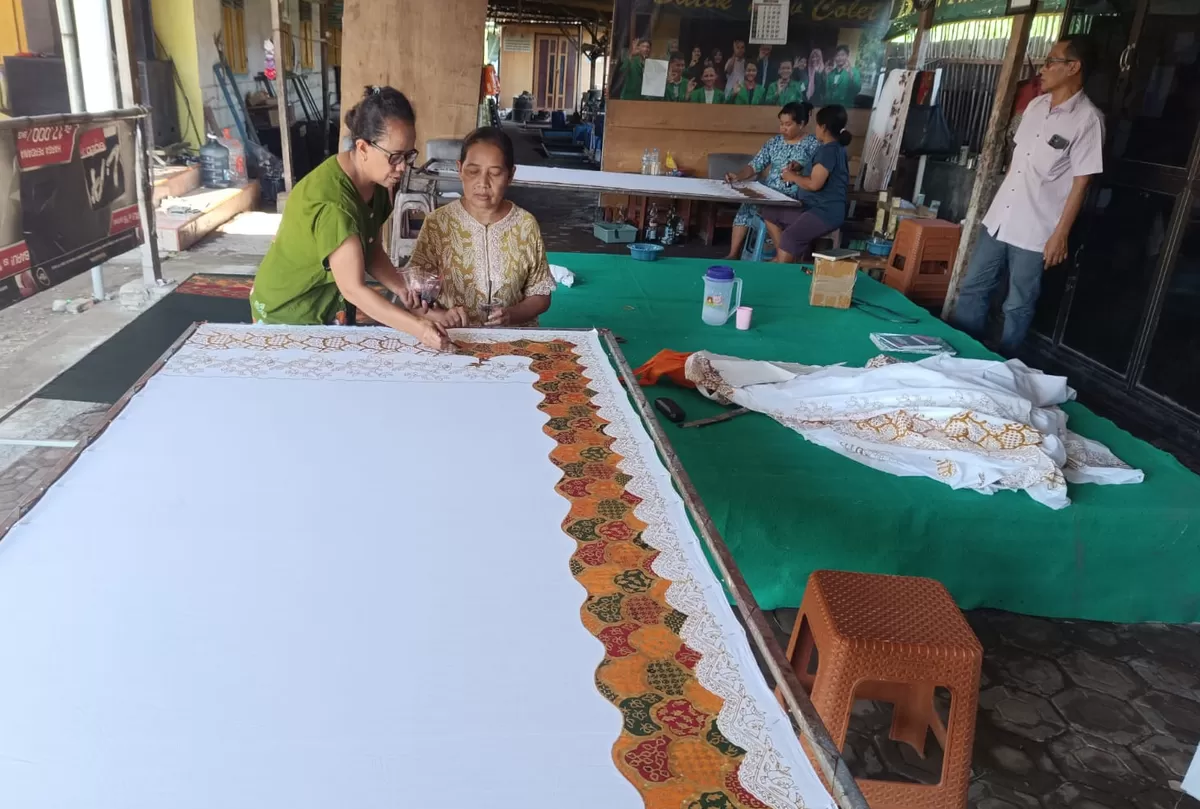 Pekerja di galeri Batik New Colet Jombang sedang menyelesaikan proses penulisan motif. (SketsaNusantara.id/As'ad Choirudin)