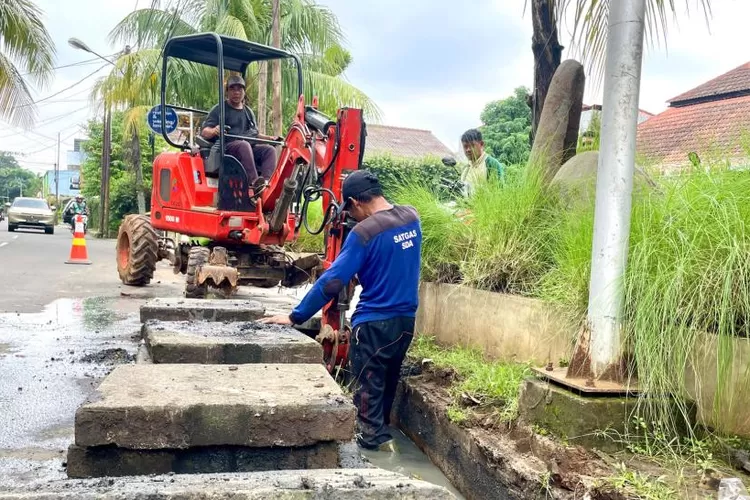 KOLABORASI : Petugas ditemani alat minispider saat melakukan normalisasi di dua saluran air yang berlokasi di Jalan Pemuda Raya, Kelurahan Depok, Kecamatan Pancoranmas, kemarin.  (RISKY DWI LESTARI/RADAR DEPOK)