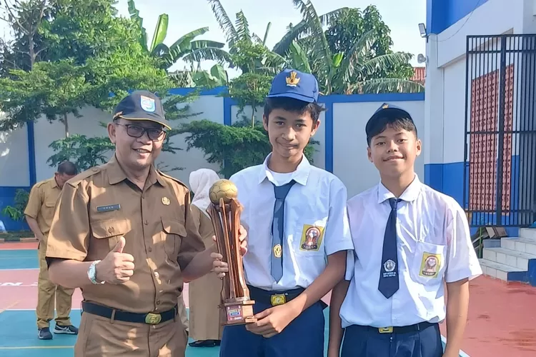 Foto bersama Kepala SMPN 30 Depok, Agus Prasetio (kiri) bersama tim sepakbola SMPN 30 Depok, usai Kejuaraan Festival Sepakbola Usia Dini. (ANDIKA EKA/RADAR DEPOK)
