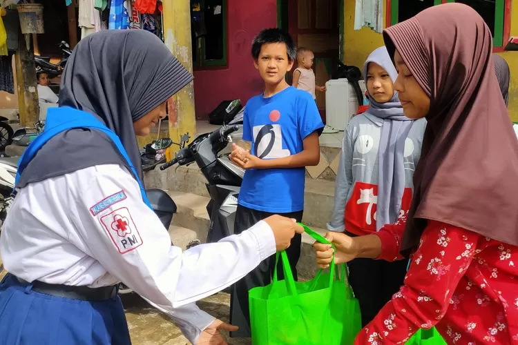 PMR SMPI Dian Didaktika dan SMP 34 Depok berikan bantuan korban banjir di Kelurahan Pondok Cina, beberapa waktu lalu. (ANDIKA EKA/RADAR DEPOK)
