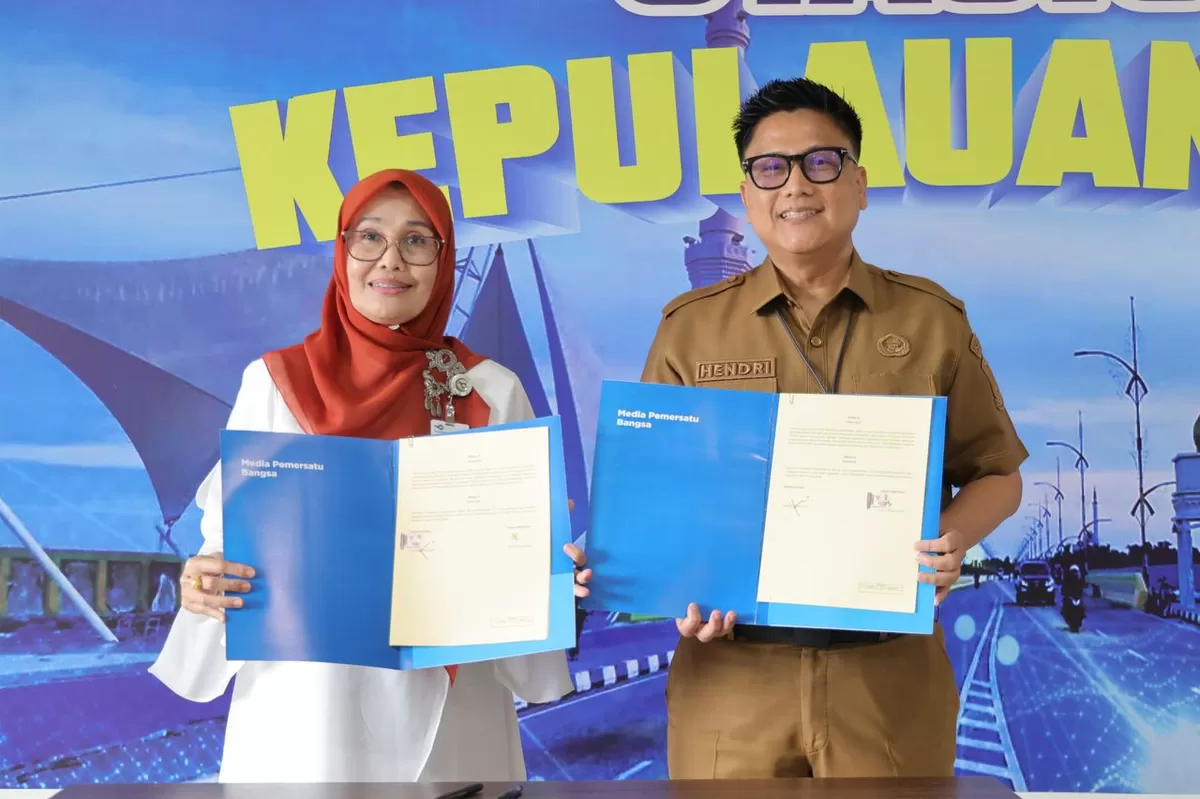 Kadis Kominfo Kepri Hendri Kurniadi dan Kepala Stasiun TVRI Kepri Yenni Marlinda, menunjukkan dokumen kerjasama yang telah ditandatangani. (Foto:Diskominfo Kepri)
