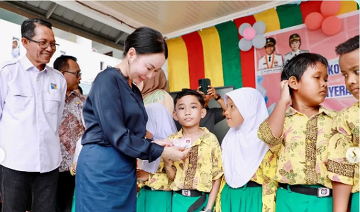 Walikota Batam Amsakar Achmad bersama Wakil Walikota Batam Li Claudia Chandra, saat membagikan kartu KIA kepada anak didi di SDN 006 Batam Kota. (Foto: Diskominfo Batam)