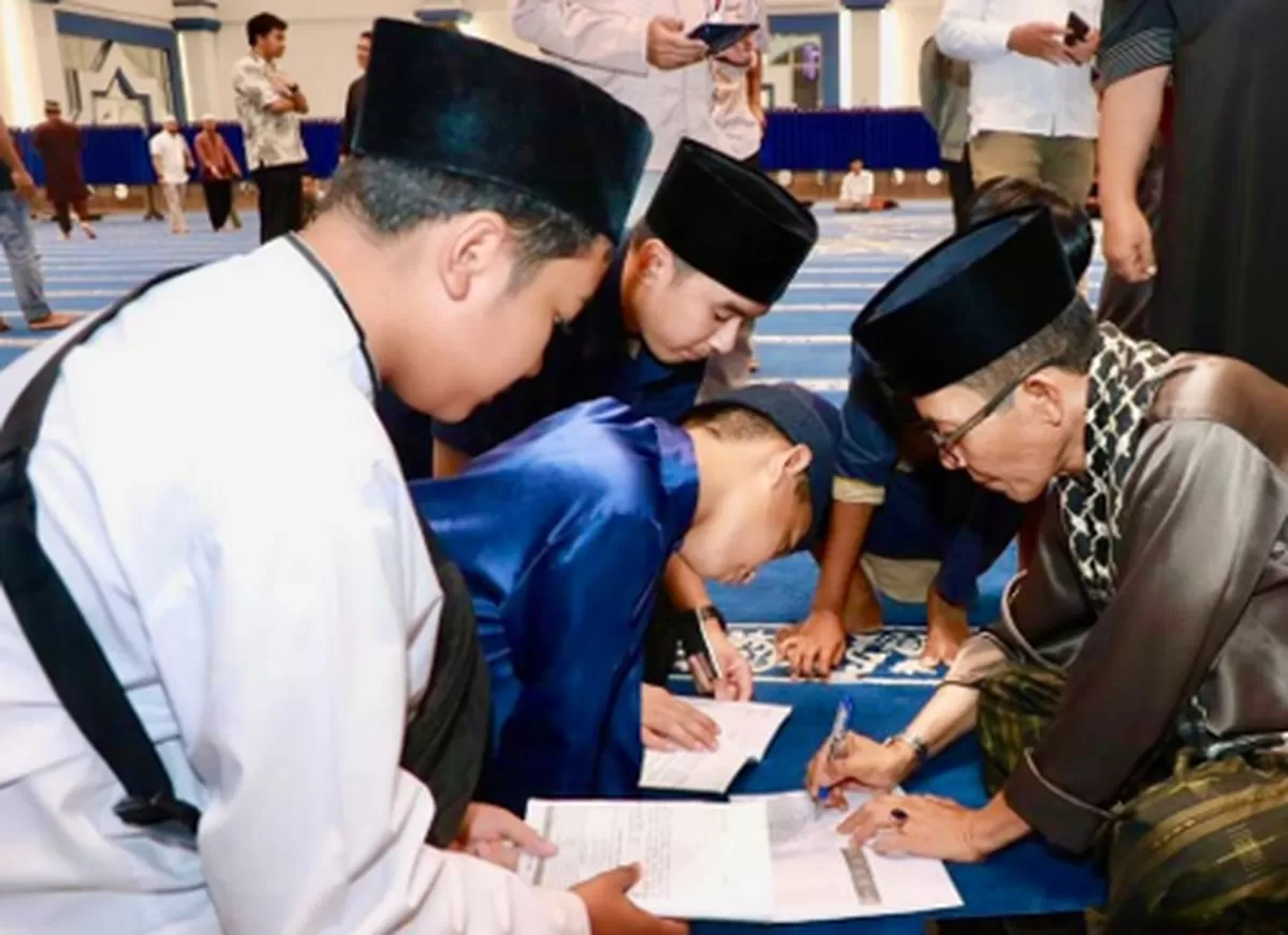 Walikota Batam Amsakar menandatangani tugas siswa pada bulan Ramadan. Saat itu Amsakar salat tarawih perdana di Masjid Raya Batam Centre. (Foto: Diskominfo Batam)