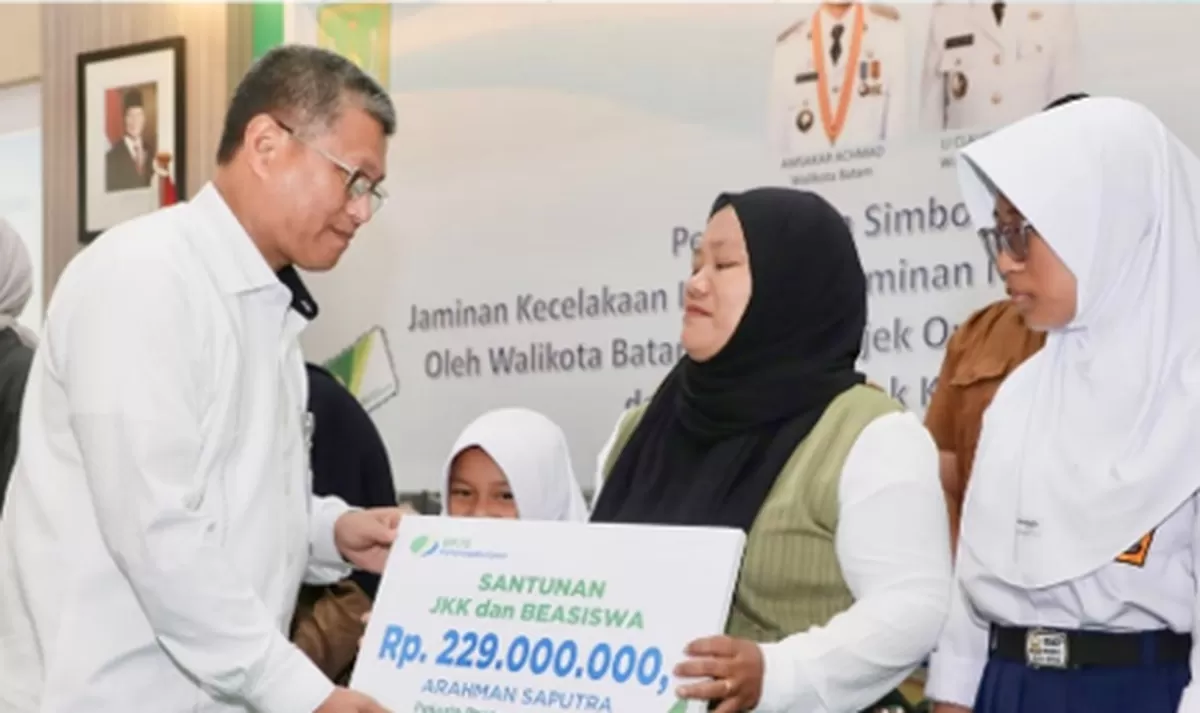 Sekda Kota Batam menyerahkan santunan JKK dan Beasiswa bersamaan dengan penyerahan  kartu BPJS Ketenagakerjaan secara simbolis kepada 10.285 pekerja rentan di Kota Batam. (Foto: Diskominfo Batam)