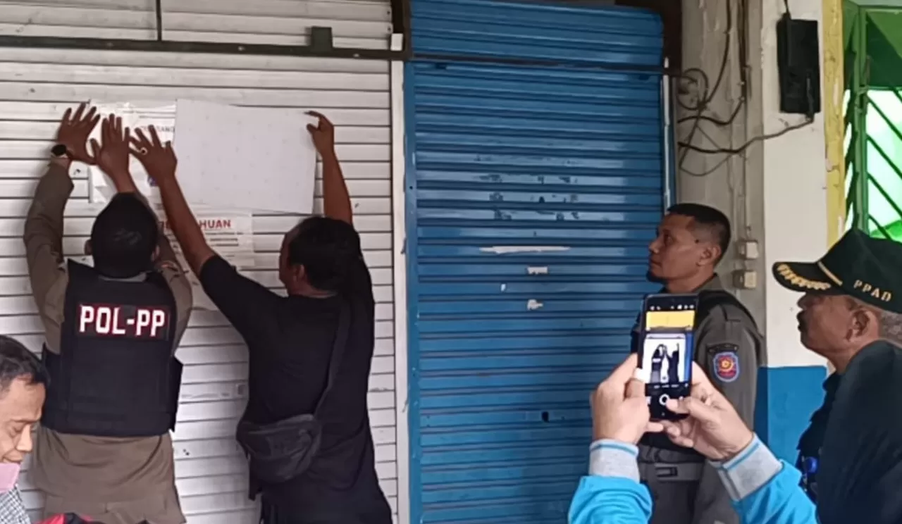 Petugas menyegel tempat usaha yang menunggak retrebusi. (dok Satpol PP Sidoarjo)