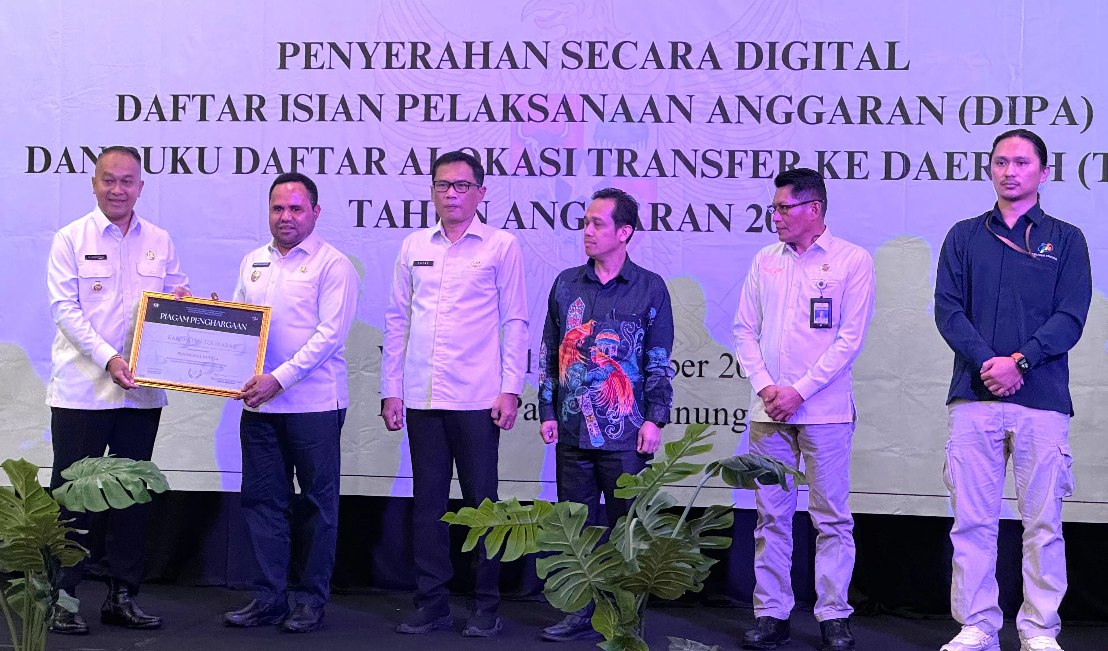 Penjabat Gubernur Prov.Papua Pegunungan, Dr. Velix Vernando Wanggai, SIP.,MPA menyerahkan penghargaan Kementerian Keuangan kepada Pj Bupati Tolikara, Marthen Kogoya, SH.,M.AP di Wamena, Rabu (18/12).  (Ceposonline.com/Diskominfo Tolikara)