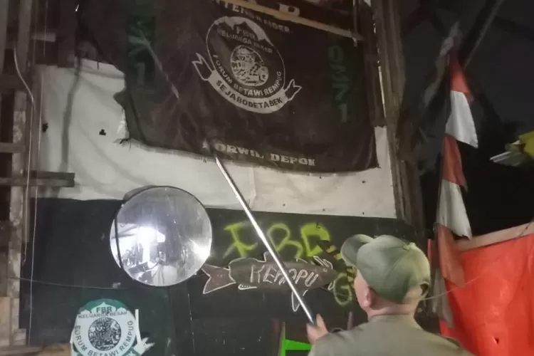 Petugas yang menertibkan atribut ormas di sekitar wilayah Sawangan dan Bojongsari (Sabojong), Senin (19/5) malam. (RISKY DWI LESTARI/RADAR DEPOK)