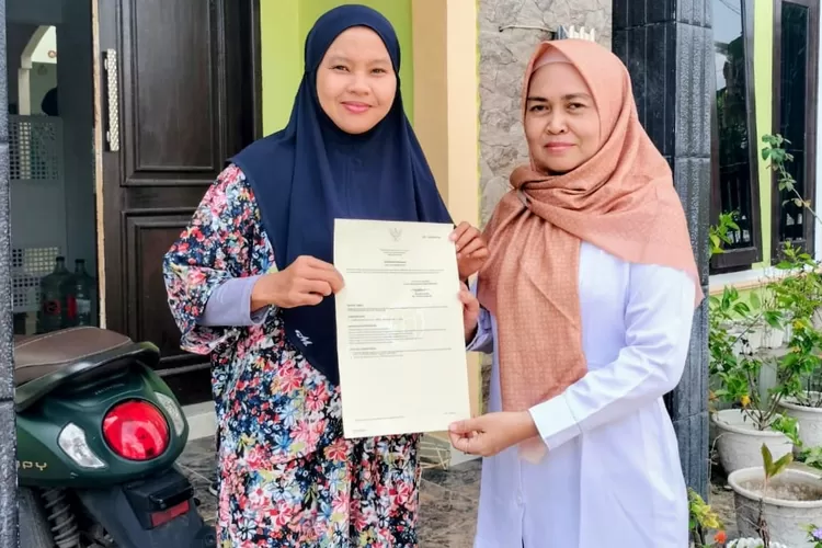 Kepala Kantah Padangsidimpuan Agustina Harahap melalui Kasubbag TU Juliyanti , menyerahkan sertifikat langsung ke rumah warga, Rabu (22/10/2025). (Foto : Realitasonline / Riswandy)