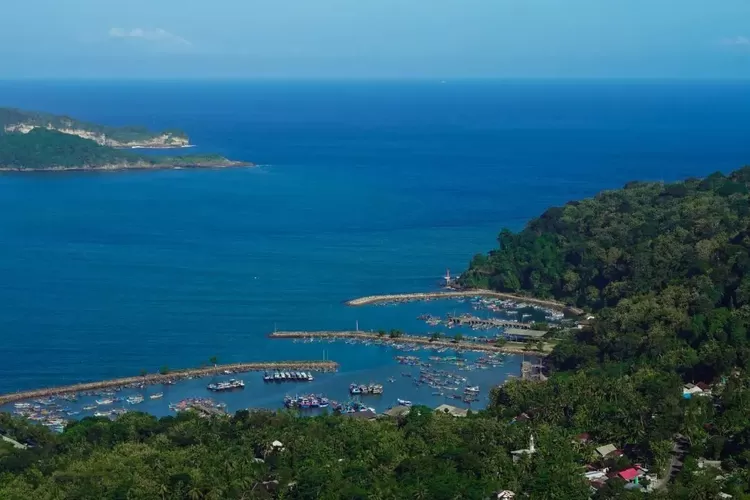 Pemandangan indah dari Pantai Klayar di Teluk Pacitan, dengan pasir putih yang bersih dan batu karang unik yang menjulang