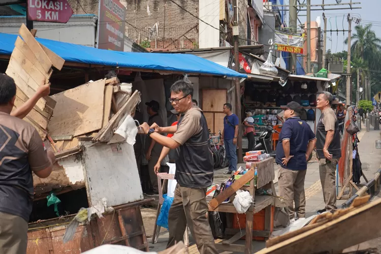 Petugas Satpol PP Kabupaten Bogor membongkar bangunan semi permanen di Simpang Pasar Cibinong yang dibangun para pedagang. (KABAR BOGOR)