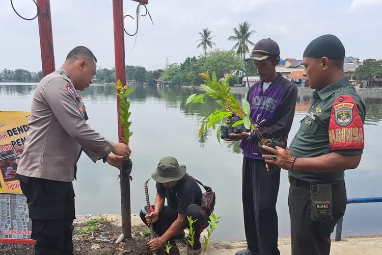 Jajaran Polsek Sukmajaya, Polres Metro Depok, melakukan penanaman pohon di tepi Situ Cilodong, RT1/2 Kelurahan Kalibaru, Kecamatan Cilodong. Penanaman pohon tersebut sebagai upaya mengantisipasi banjir dan tanah longsor. (Andika Eka/Radar Depok)