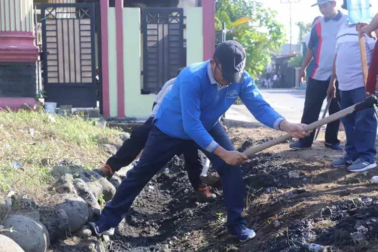 Wako Hendri Septa tampak mencangkul membersihkan drainase saat Padang Bagoro  di Kelurahan Banuaran Nan XX, Kecamatan Lubuk Begalung. (dok.Prokopim Pdg)