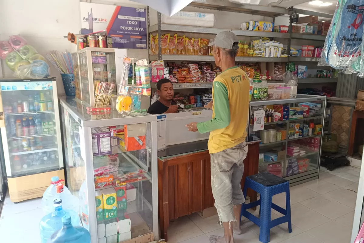 Hariadi sedang melayani pelanggan di Agen BRILink  yang dikelolanya. (SketsaNusantara.id/As'ad Choirudin)