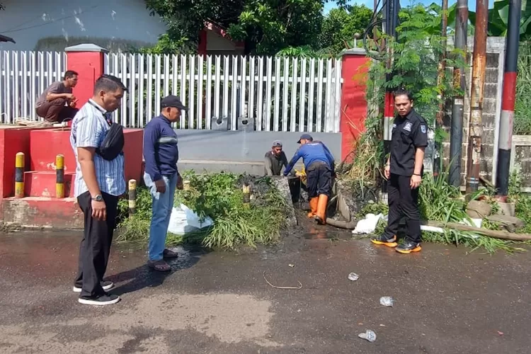 Aparatur Kelurahan Harjamukti melakukan penanganan sementara pada saluran air yang meluap pada Jalan Telkom, yang terletak di RW3 Kelurahan Harjamukti (Andika Eka/Radar Depok)