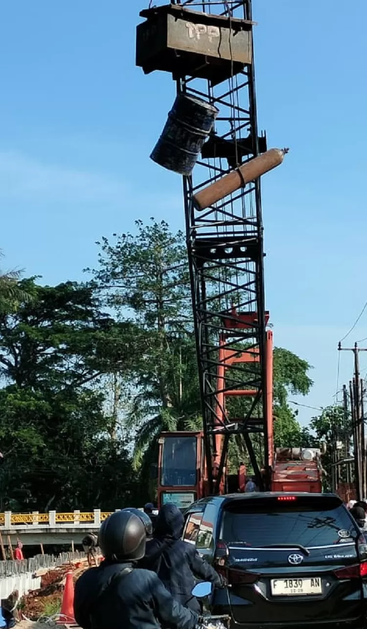 Pemberat crane yang menggantung : peti besi, tabung gas dan tong di Jalan Raya Grogol, Kelurahan Grogol, Limo, Depok, bisa kapan saja membuat pengendara pindah alam, Selasa (2/9).