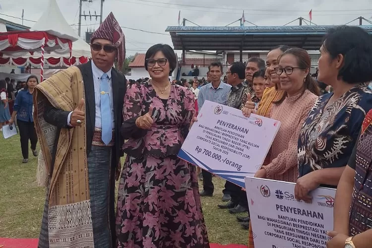 Bupati Taput Dr. Jonius Taripar Hutabarat didampingi Sarma Hutajulu Humas PT Gading Energi Prima saat menyalurkan dukungan beasiswa ke pelajar. (Realitasonline.id - AS)