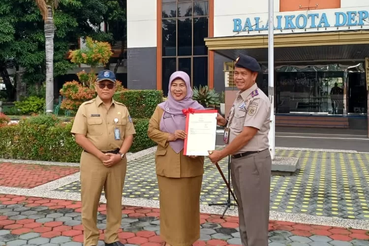 Penyerahan secara simbolis sertipikat tanah elektronik yang diberikan oleh Kepala Kantor Pertanahan Kota Depok, Rahmat kepada PJ Sekda Kota Depok, Nina Suzana di Lapangan Apel, Balaikota Depok. (MONICA REISTIE/RADAR DEPOK)