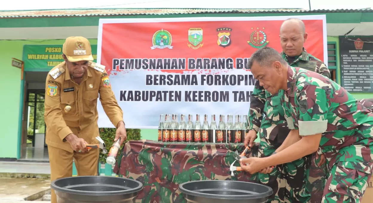 Bupati Keerom, Piter Gusbager, saat memusnahkan 600 botol miras, didampingi Dandim 1702 Jayapura, Danramil Arso, di Makoramil Arso, Selasa (18/3/2024). (CEPOSONLINE.COM/Mustakim Ali)