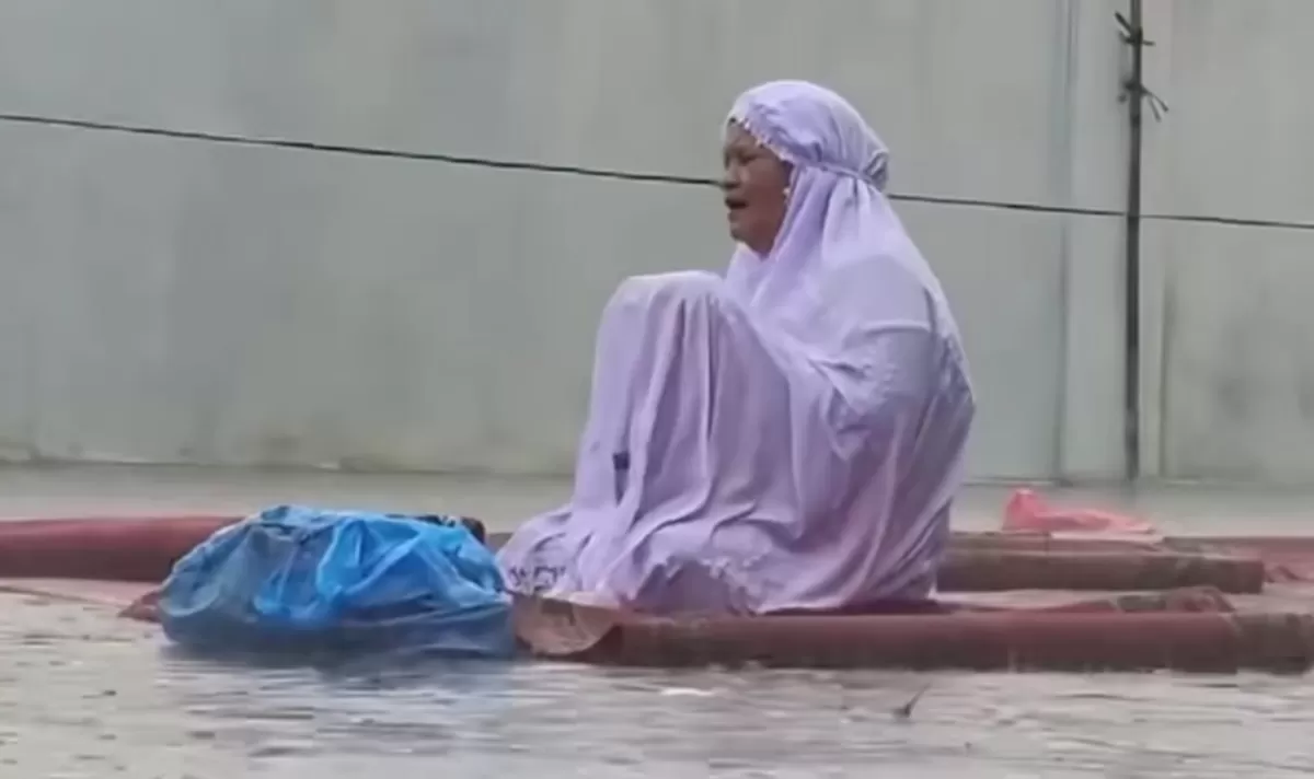 Momen seorang ibu yang terus berdoa meski hujan turun dengan deras. (Instagram/pekanbarutalks)
