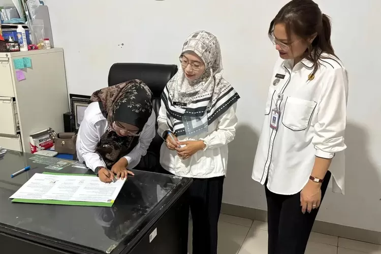 Lurah Baktijaya Resky Desa Ismayawati saat melakukan penandatanganan serah terima arsip digital Letter C di Kantor Kelurahan Baktijaya, Rabu (19/11). (DOKUMEN PEMKOT DEPOK)