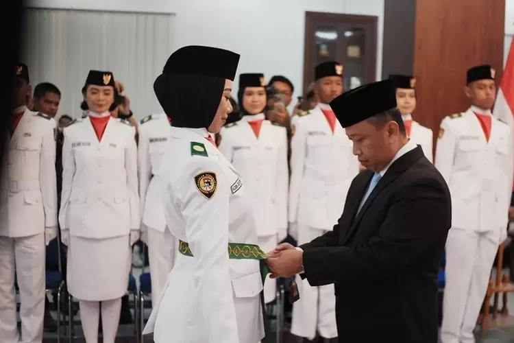 Walikota Depok Supian Suri menyematkan kendit kepada salah satu anggota Paskibraka Kota Depok tahun 2025, Jumat (15/8). (PEMKOT DEPOK)