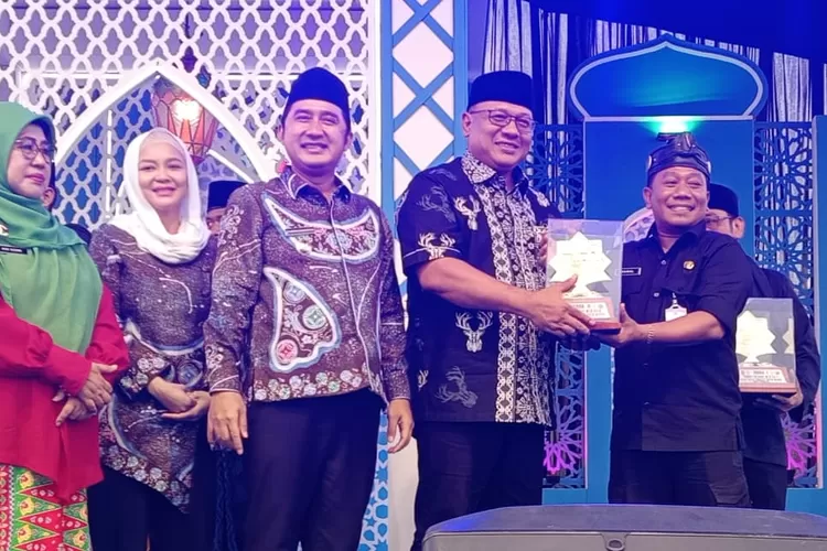 Anggota DPRD Provinsi Jawa Barat, Pradi Supriyatna menyerahkan piala, untuk juara kedua kepada Camat Cilodong, Zaenal Arifin, di Lapangan Cipayung, Kecamatan Cipayung, Kota Depok, Kamis (13/11). (AGNESYA WIANDA/RADAR DEPOK)
