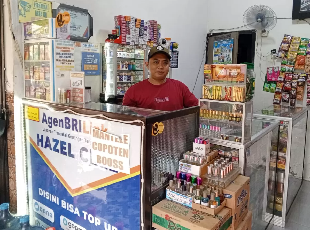 Abdul Munir saat berada di Agen BRILink miliknya. (SketsaNusantara.id/As'ad Choirudin)