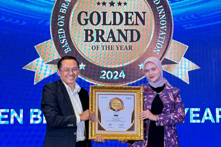 Nadya Dharmawati Puteri selaku Digital Media Section Head JNE mewakili penerimaan penghargaan Golden Brand of The Year 2024, yang diserahkan oleh langsung oleh Tri Raharjo selaku CEO Tras N Co Indonesia. (DOK JNE)