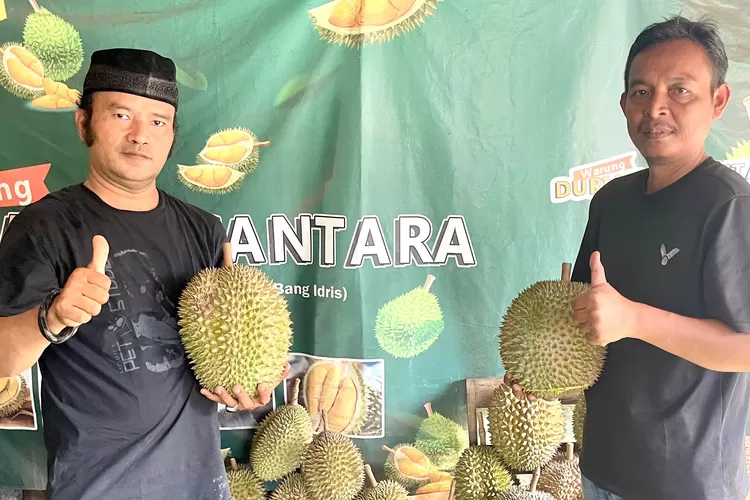 LEGIT : Pemilik Warung Durian Nusantara, Idris Saputra (kiri) memegang durian diantara kudapan Durian yang berlokasi di Jalan Raya Curug, RT1/7 Kelurahan Curug Kecamatan Bojongsari, Sabtu (11/1/2025).  (RISKY DWI LESTARI/RADAR DEPOK)