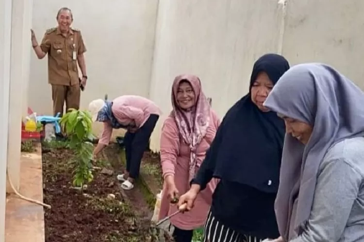 MENANAM : Penghijauan taman Kelurahan Mampang bersama lurah Mampang Darmawansyah (kiri) dengan Kader PKK Kelurahan Mampang, Kecamatan Pancoranmas, Senin (21/1). (RISKY DWI LESTARI/RADAR DEPOK)