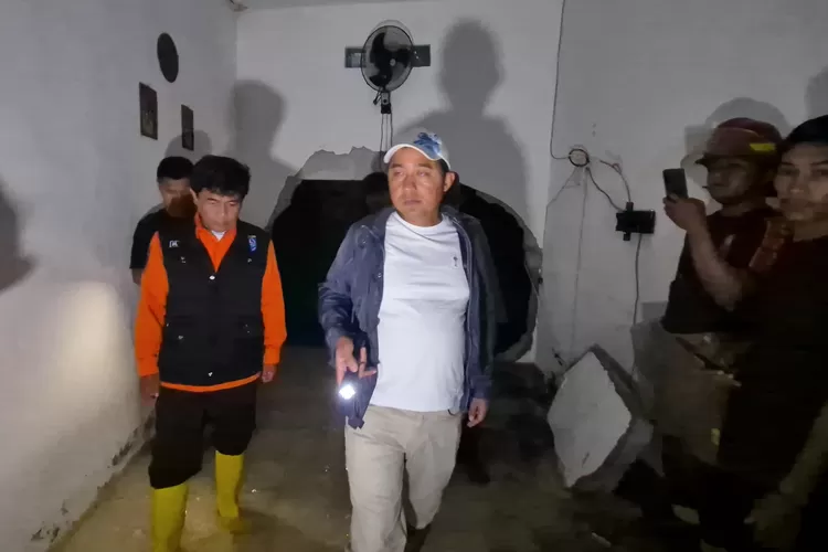 TINJAU : Wakil Walikota Depok, Chandra Rahmansyah, saat meninjau rumah yang jebol akibat longsor yang terjadi di Perumahan RGS, Kelurahan Rangkapanjaya Baru, Kecamatan Pancoranmas, Sabtu (8/3) malam. (ALDY RAMA/RADAR DEPOK)