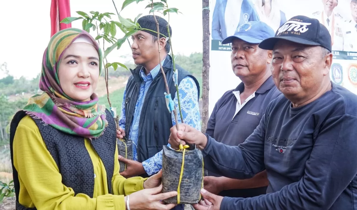 Ketua BKOW Provinsi Kepri Nenny Dwiyana Nyanyang menyerahkan 700 bibit tanaman perkebunan secara simbolis kepada kelompok tani di Cikolek Toapaya Selatan. (Foto:Diskominfo Kepri)