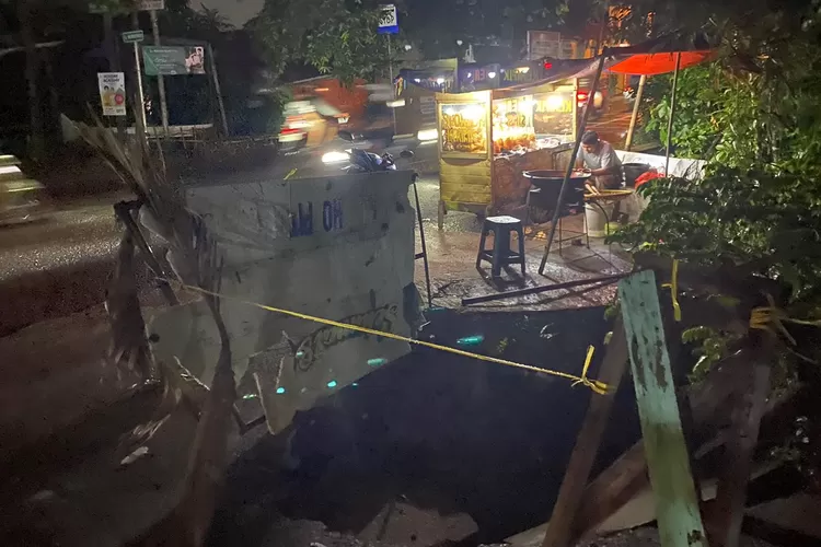 RUSAK : Kondisi terkini jalan amblas yang terjadi di Jalan Merpati Raya, Kelurahan Depok Jaya, Kecamatan Pancoranmas, Kota Depok, Senin (22/4). (ALDY RAMA/RADAR DEPOK)