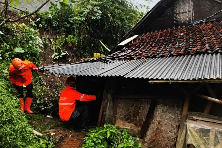 Petugas BPBD Kabupaten Bogor melakukan penanganan rumah yang terkena TPT longsor. (ISTIMEWA)