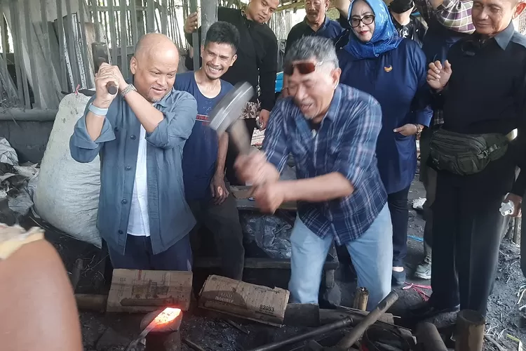 TEMPA : Bacalon Gubernur Jabar dari Partai Nasdem, Ilham Akbar Habibie mencoba menempa besi yang akan dijadikan golok di salah satu industri rumahan yang ada di Desa Mekarmaju, Kecamatan Pasirjambu, Kabupaten Bandung, Kamis (11/7). (PUTRA WAHYU PURNOMO/RADAR BANDUNG)