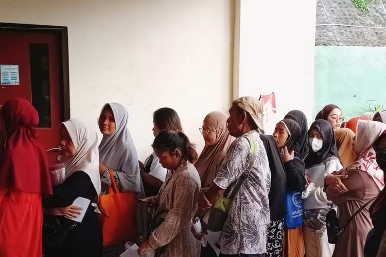 Warga penerima manfaat bantuan langsung tunai (BLT) kesra yang berlokasi di Kantor Kelurahan Pancoranmas, Kecamatan Pancoranmas, Sabtu (29/11). (RISKY DWI LESTARI/RADAR DEPOK)