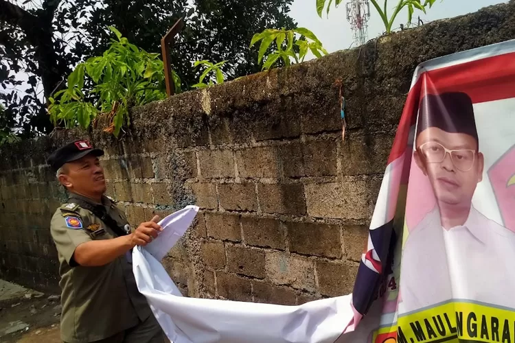 Penertiban APS Caleg dan Capres di Jalan Ciherang Raya, Kelurahan Sukatani, Kecamatan Tapos. (ANDIKA EKA/RADAR DEPOK)