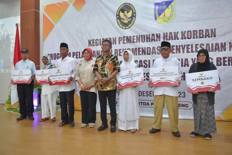 Gubernur Rusdy Mastura (tengah) foto bersama dengan korban dan keluarga korban pelanggaran HAM berat tahun 1965-1966 yang menerima santunan dari negara. (Foto: Ist). 