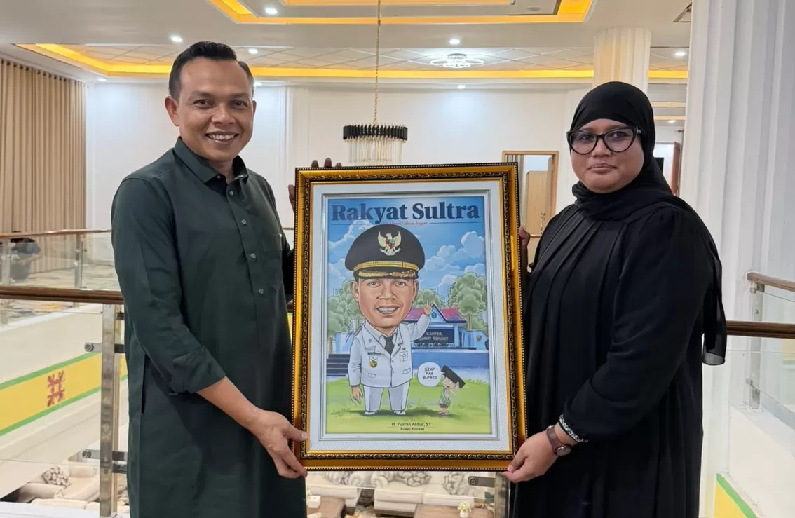 Direktur Harian Rakyat Sultra Syarifah Mulya saat memberikan Karikatur ke Bupati Konawe  H Yusran Akbar. 