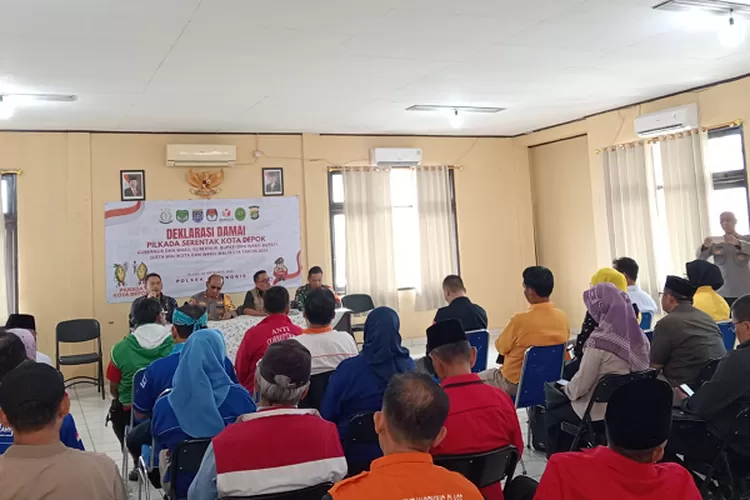 Kapolsek Cimanggis Kompol Tatang Targana, PLT Camat Tapos Suhendar saat menandatangani deklarasi Pilkada Damai 2024 di Aula Polsek Cimanggis, Selasa (24/9).  (AGNESYA WIANDA/RADAR DEPOK)